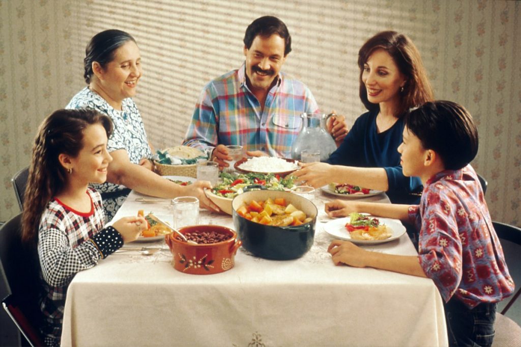 Large family group sharing a meal at a long table