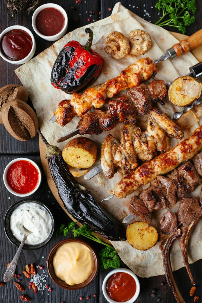Charcoal-grilled meat skewers with vegetables on a serving board