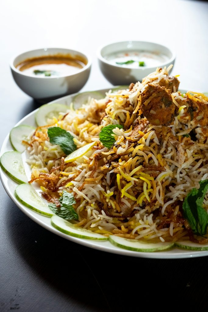 Mutton kacchi biryani with potato and boiled egg on a white plate