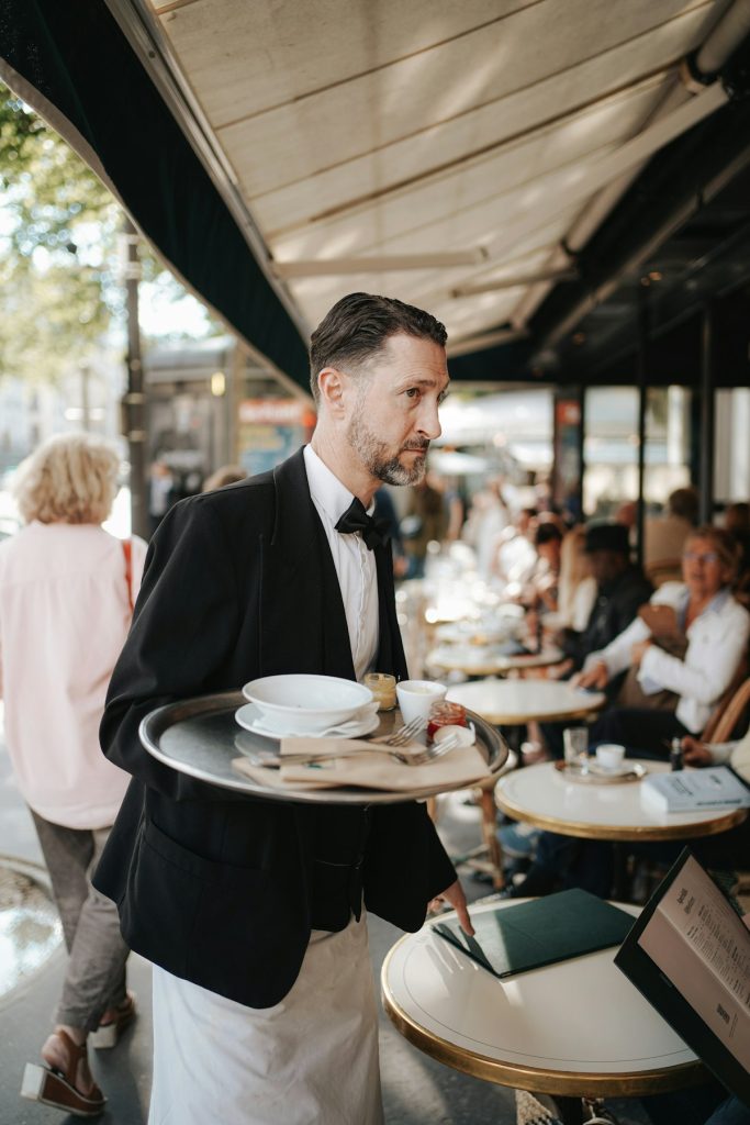 Server in formal attire carrying plates to a table